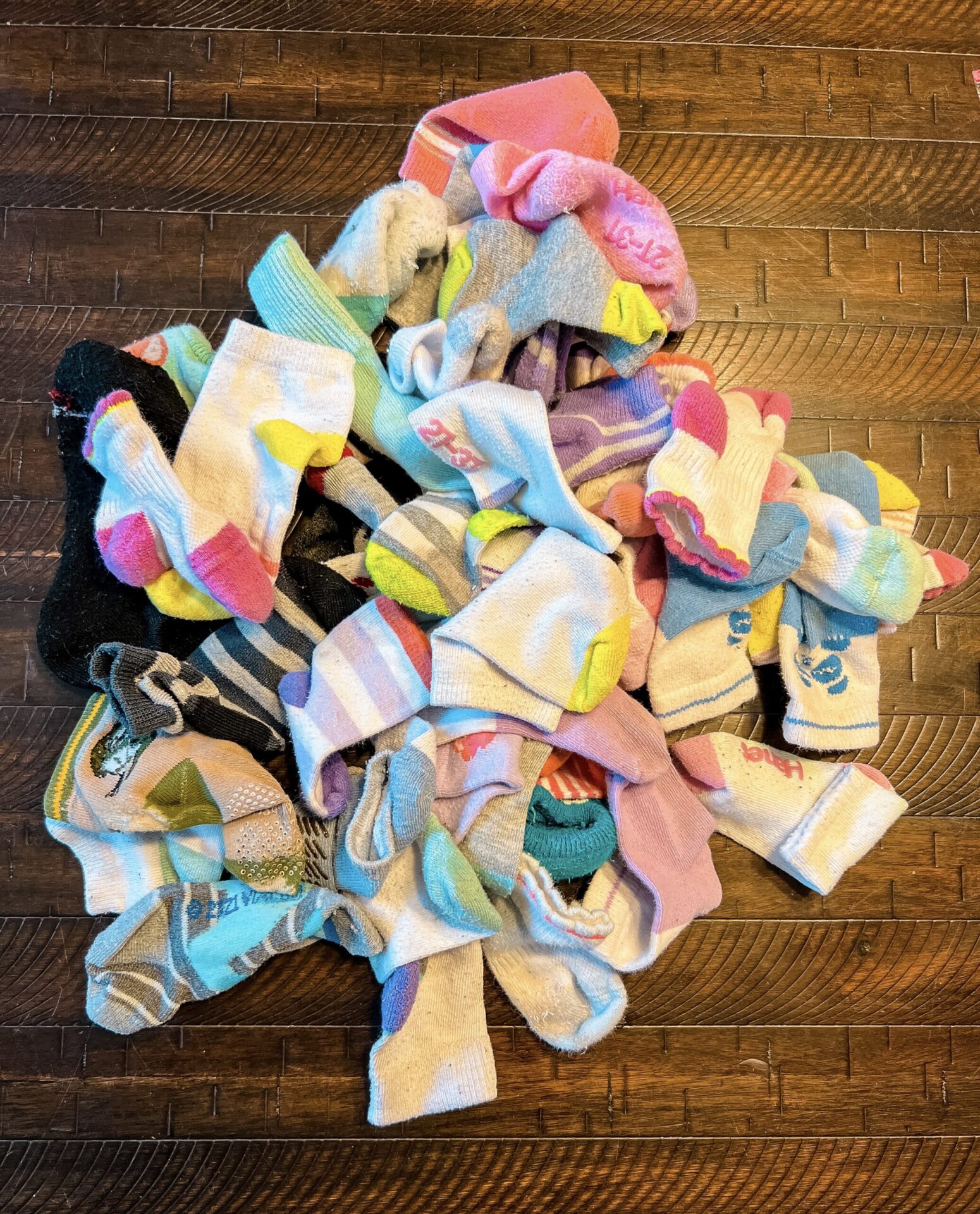 Pile of mismatched socks to make DIY knee pads for babies and toddlers.