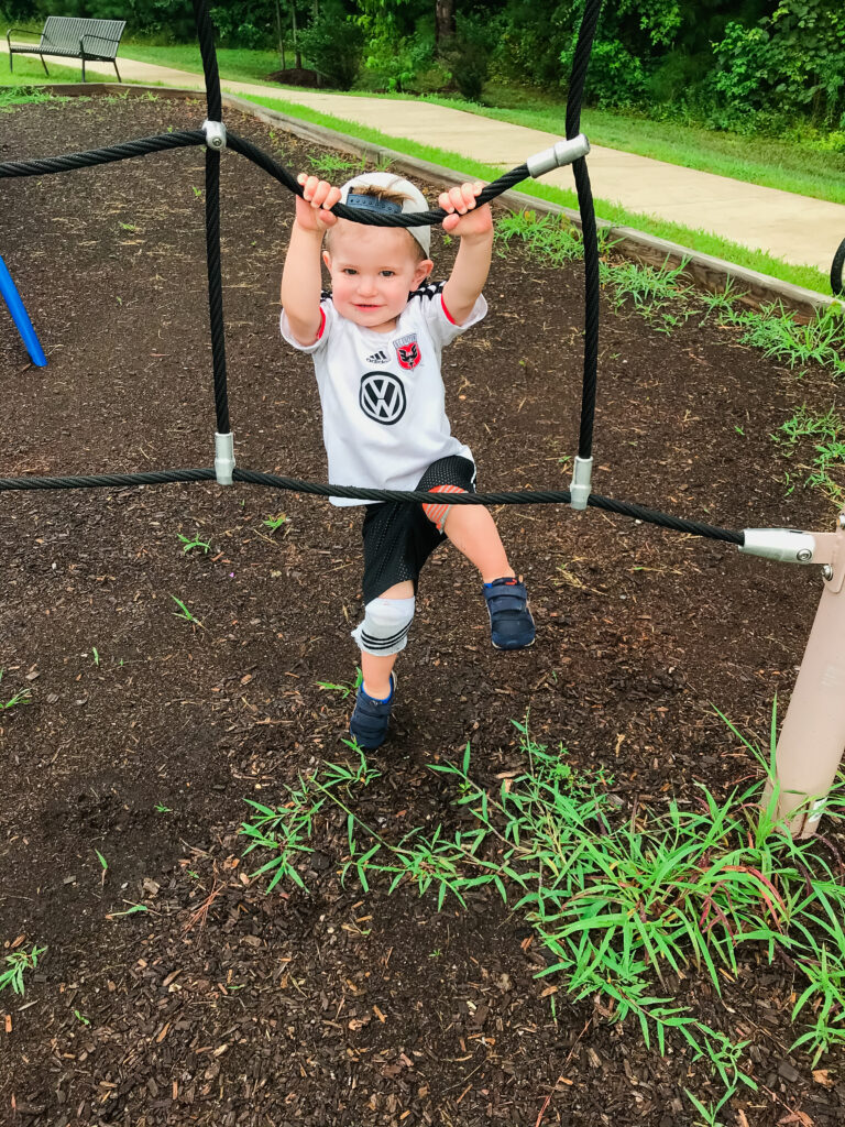 Toddler boy wearing DIY knee pads on the playground.