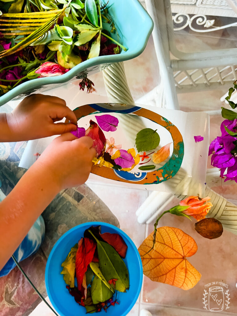 Child's hands crafting a flower suncatcher.