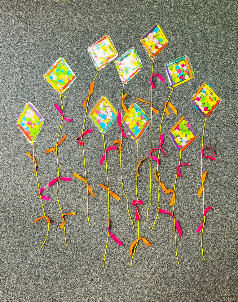 Spring Kite Craft made with popsicle sticks, tissue paper, transparent paper, yarn, and ribbon.