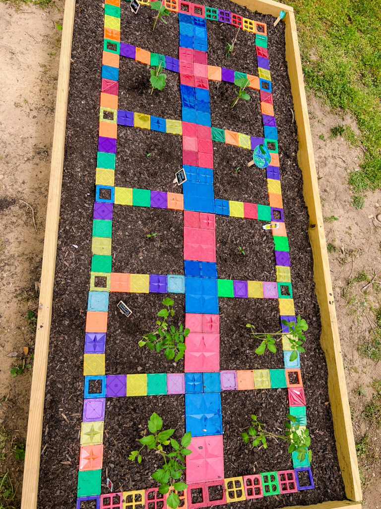 Top view of raised garden bed using manga-tiles to separate vegetable plots.