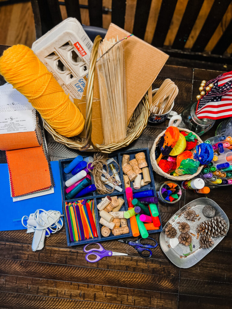 DIY Boats Materials: Jumbo popsicle sticks
Colorful popsicle sticks
Paint sticks
Foam craft paper
Twine
Yarn
Scissors
Markers
Crayons
Hot glue gun 
Plastic table cloth
Small American Flags (in honor of the Veterans on Memorial Day)
Cake toppers 
Cardboard
Wine corks
Pinecones
Empty egg carton
Toilet/Paper towel rolls
