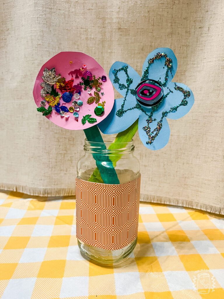 Spring flower crafts are made from cardstock, paper, confetti, glitter, and a button.