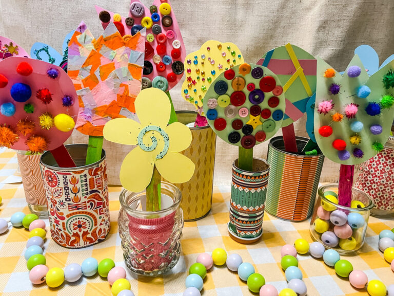 Spring Flowers made from cardstock paper, buttons, pom poms, confetti, and more craft items.
