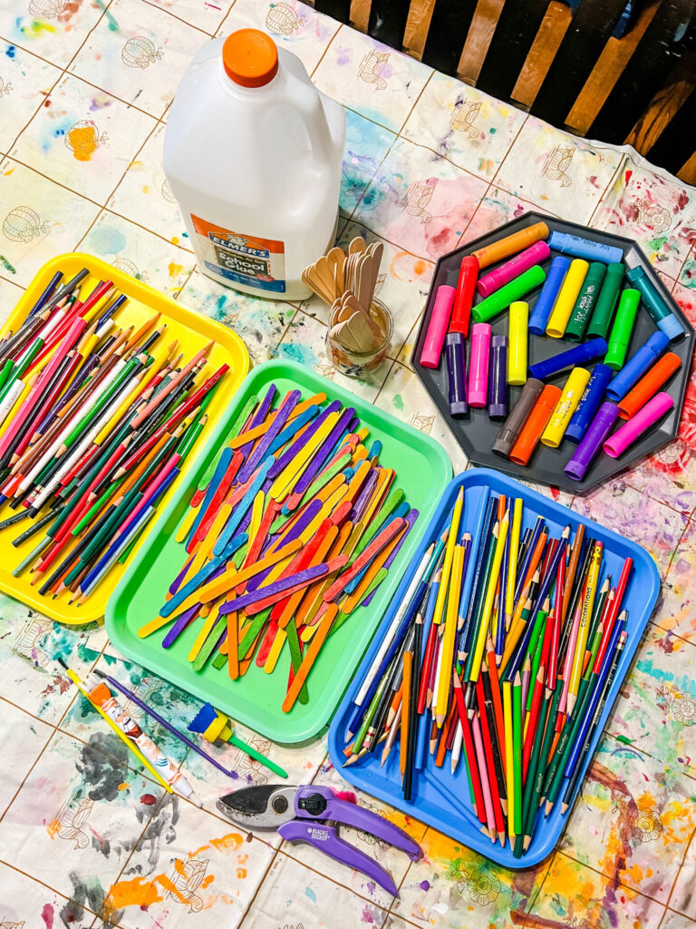DIY garden fairy home supllies: colored pencils, popsicle sticks, paint sticks, hot glue gun.