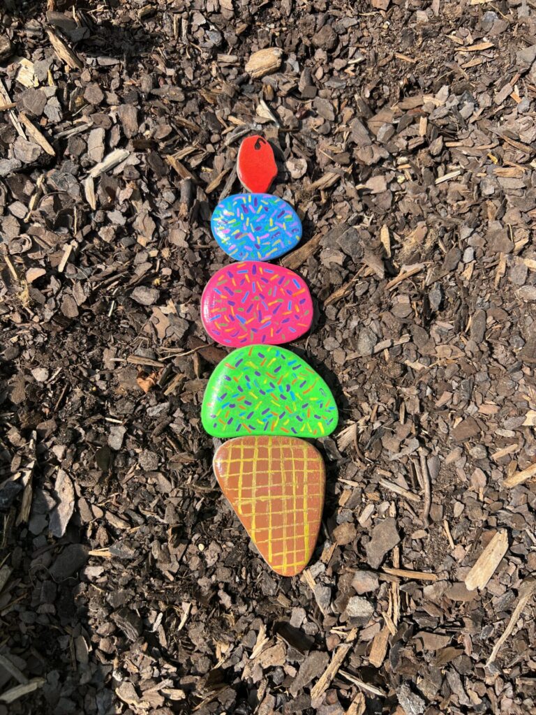 Garden Rock Art with five rocks making and Ice cream cone with three scoops of ice cream and a cherry on top.