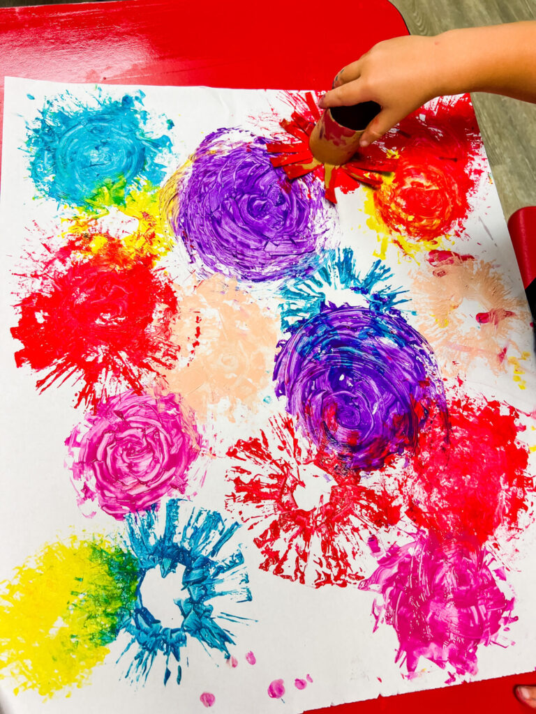 Summer Crafts - Child making fireworks using paint and toilet paper rolls