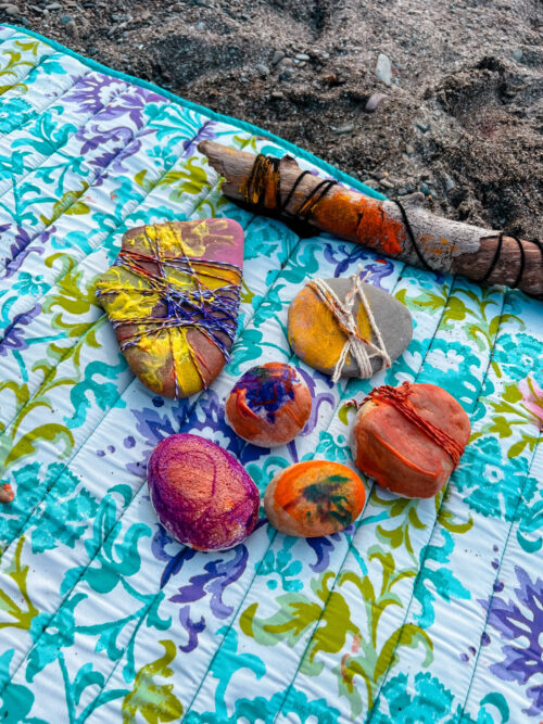 Rock Art at the Beach. Rocks are crafted with paint, markers, and pieces of string.