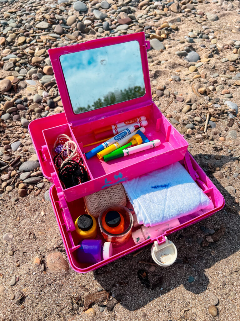 Rock Art Materials like dried out markers, string, and paint stored in a caboodle,