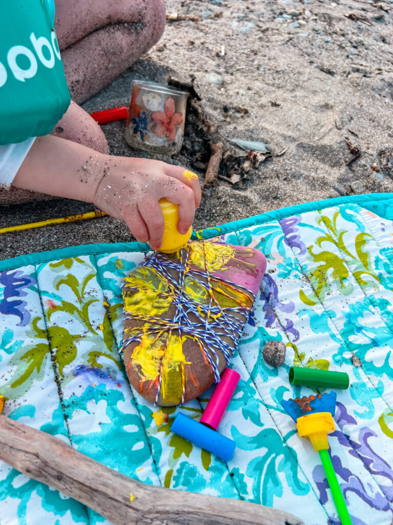 Rock Art on the beach with paint and string.