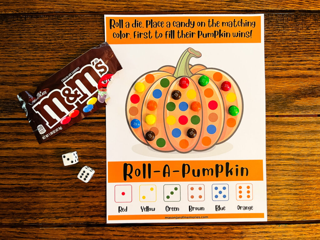 Fall Games for Kids: Pumpkin Game Board with dice and a bag of M & Ms.