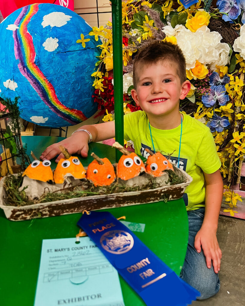 Egg Carton Pumpkins won a first at the county fair! Young boy smiling behind his egg carton pumpkins.