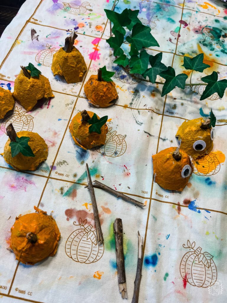 Egg Carton Pumpkins with sticks and ivy inserted into the orange egg carton pumpkins.