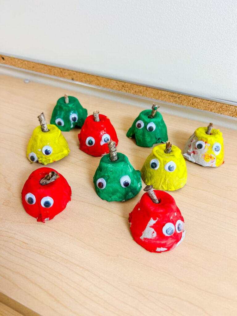 Egg Carton Apples made from egg cartoons and painted red, green, and yellow. Googly Eyes and sticks for stems.