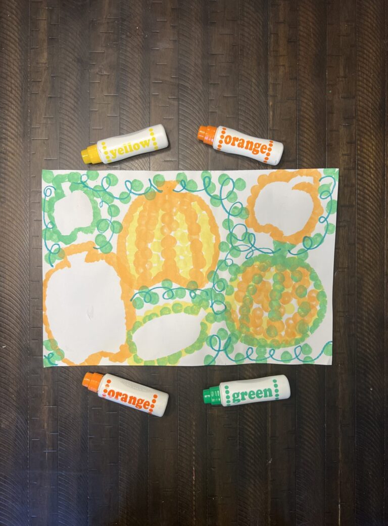Pumpkin Dot Art wit a large white construction paper with various pumpkins and wines created by dot markers.